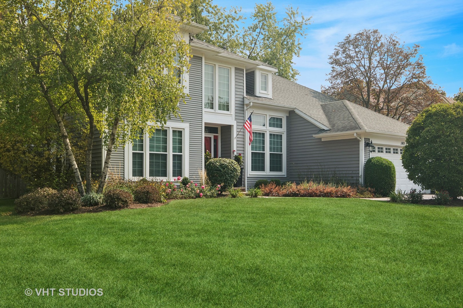 a front view of a house with a garden and yard