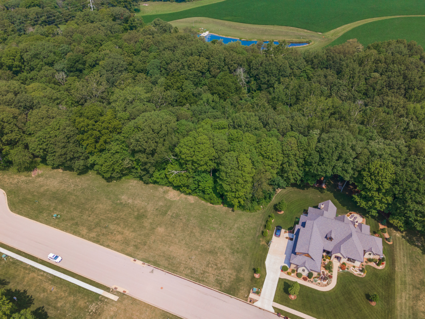 an aerial view of a house with a yard and lake view