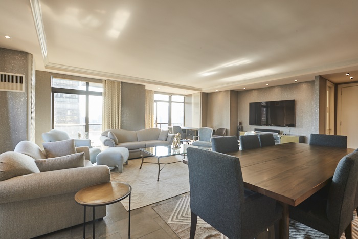 a living room with furniture a flat screen tv and a large window