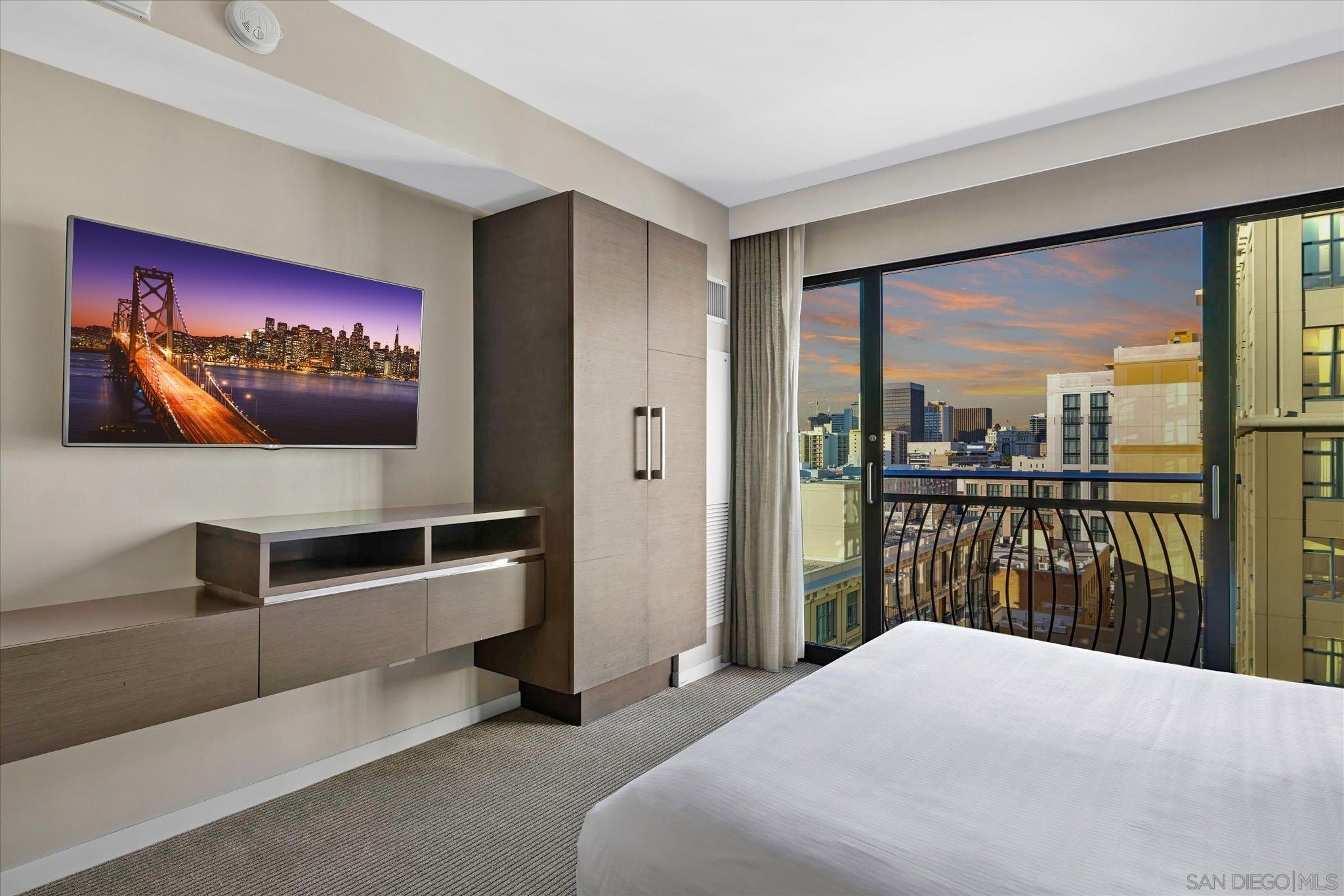 a bedroom with a large bed and a flat tv screen on dresser