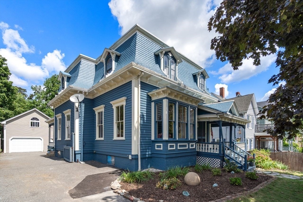 a view of a house with a yard and floor to ceiling windows