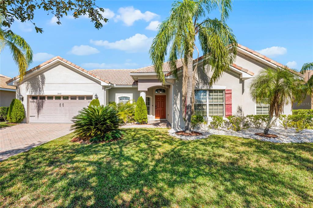 a view of a house with a palm tree and a yard