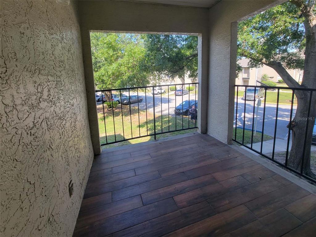 a view of a room with wooden floor and a floor to ceiling window