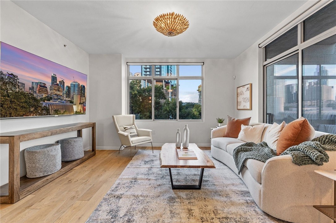 a living room with furniture a rug and a floor to ceiling window