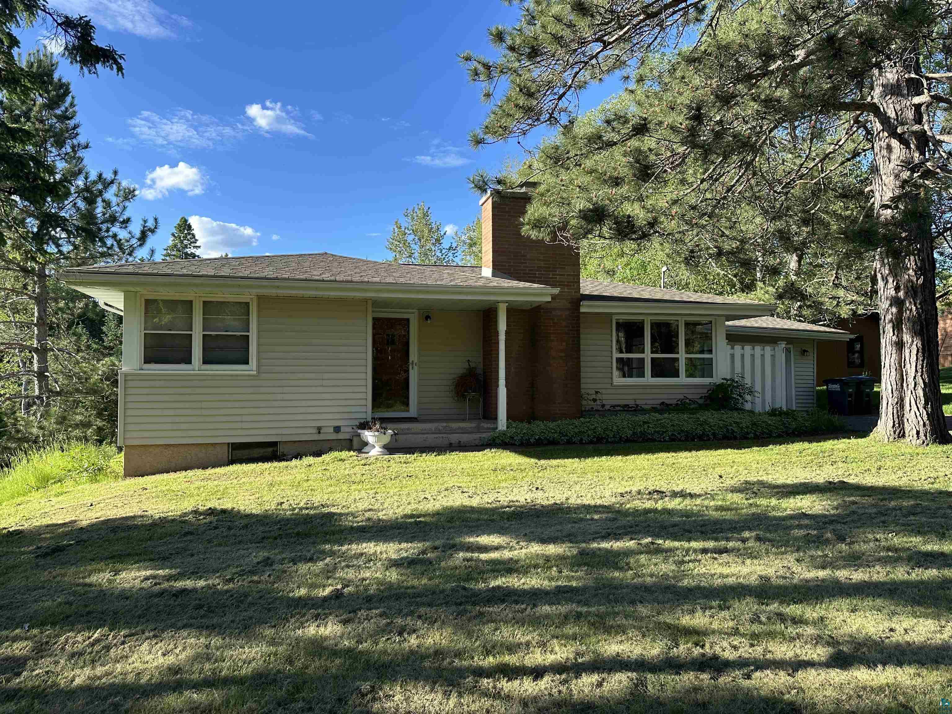 Ranch-style home with a shaded front yard.