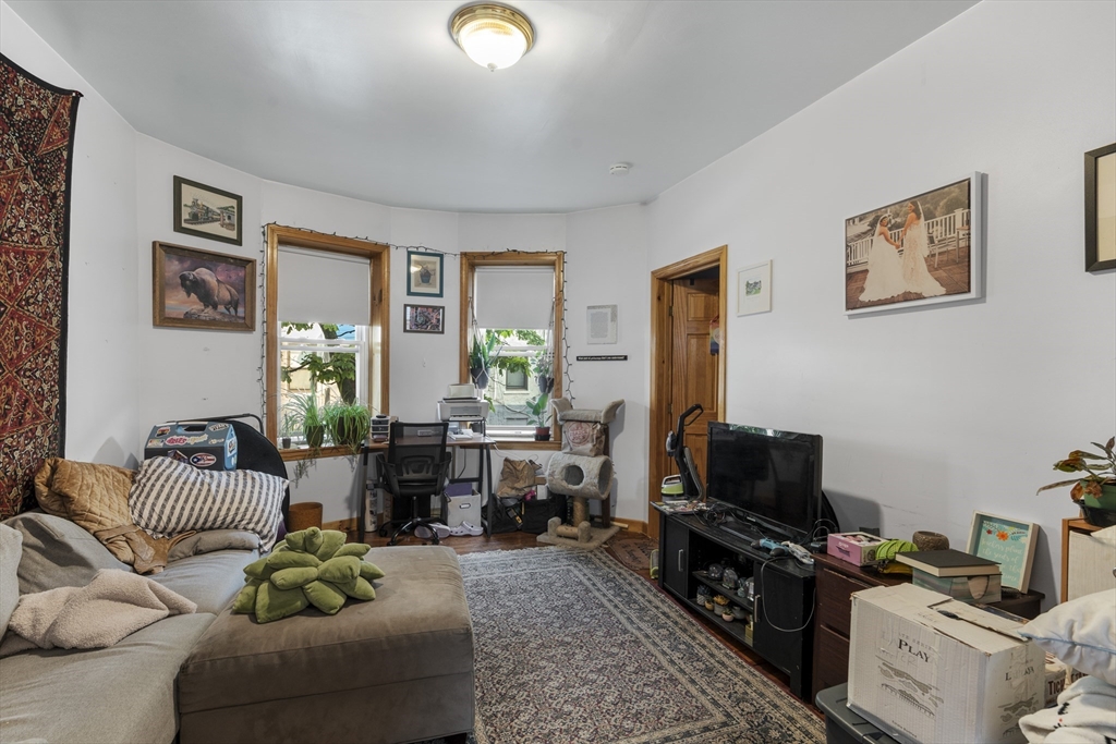 a living room with furniture a flat screen tv and a window