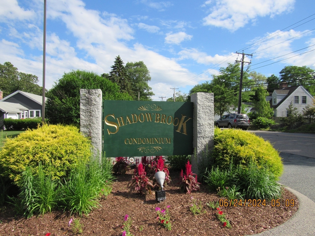 a sign that is sitting in front of flowers