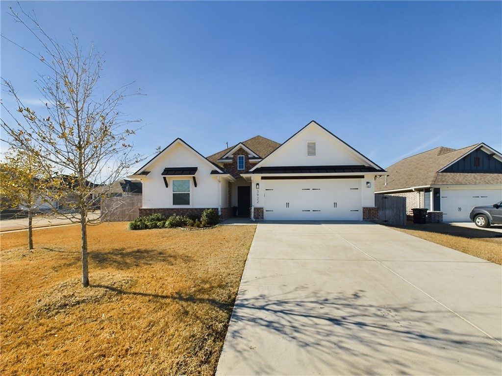 View of front of home with a front yard and a gara