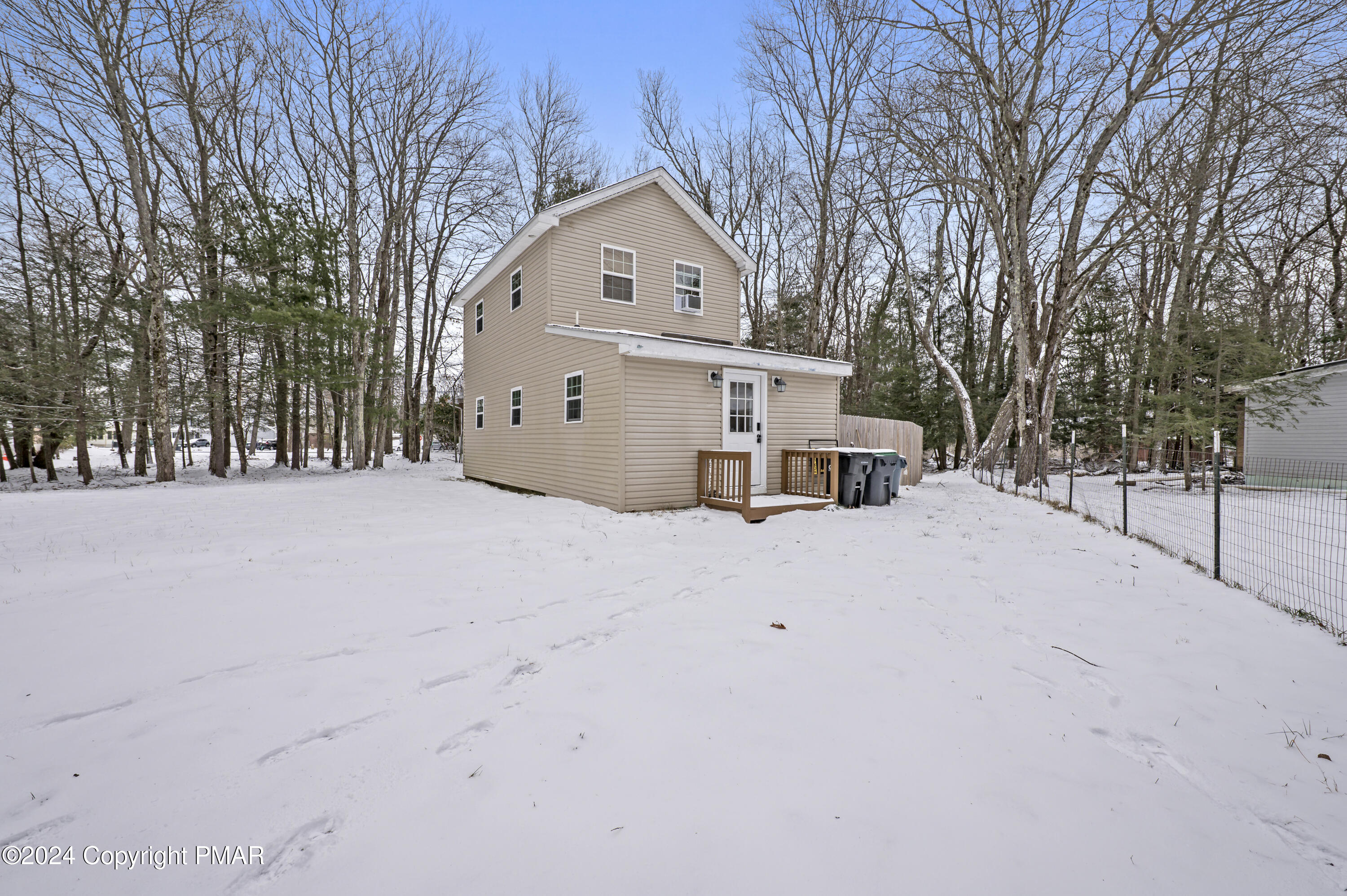 a front view of a house with a yard covered with snow