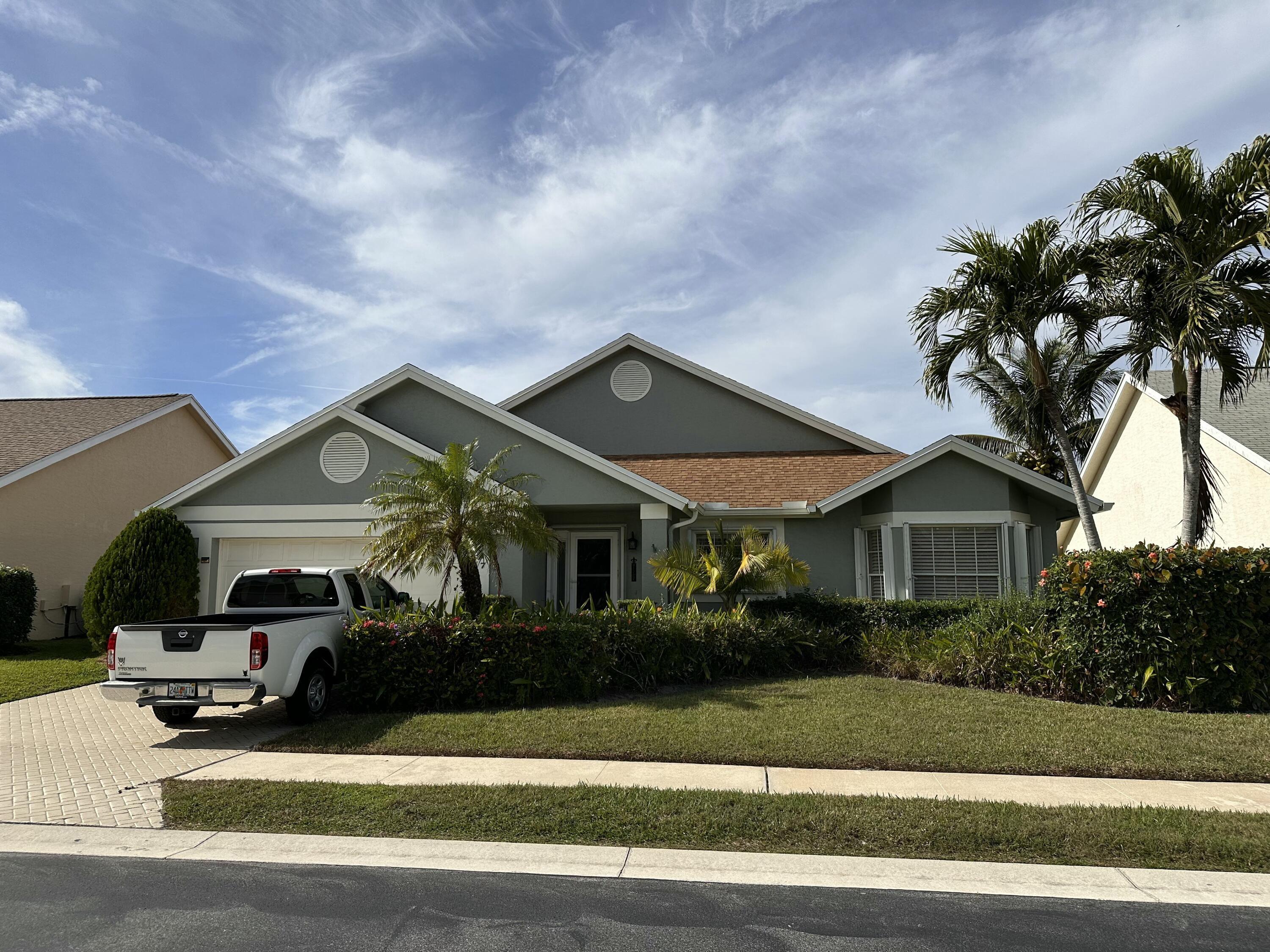 a front view of a house with a yard and potted plants