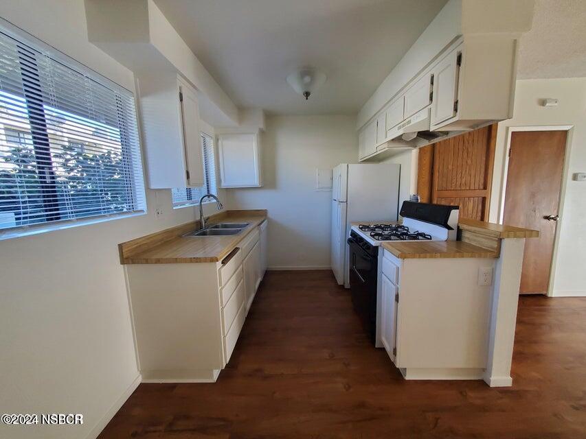 a kitchen with sink a refrigerator and cabinets