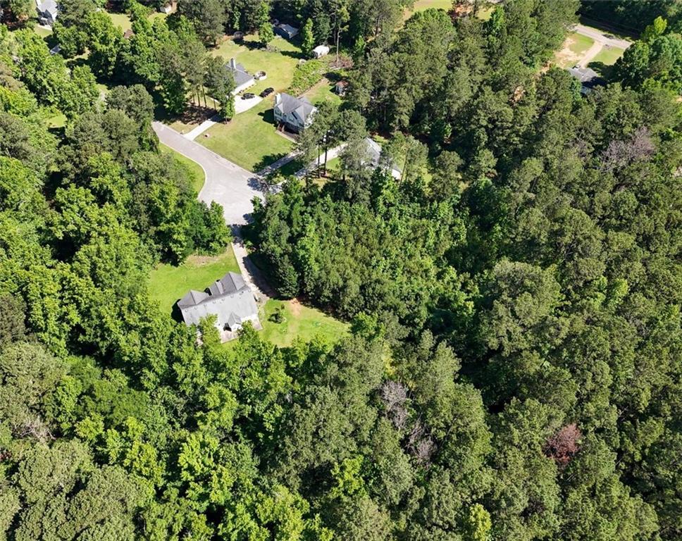 an aerial view of residential house with outdoor space and trees all around