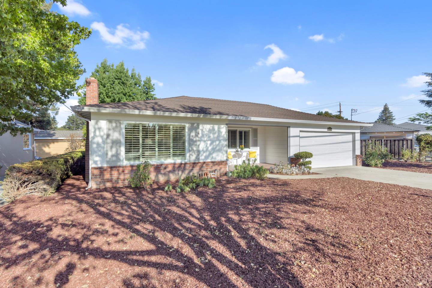 a front view of a house with a garden and yard