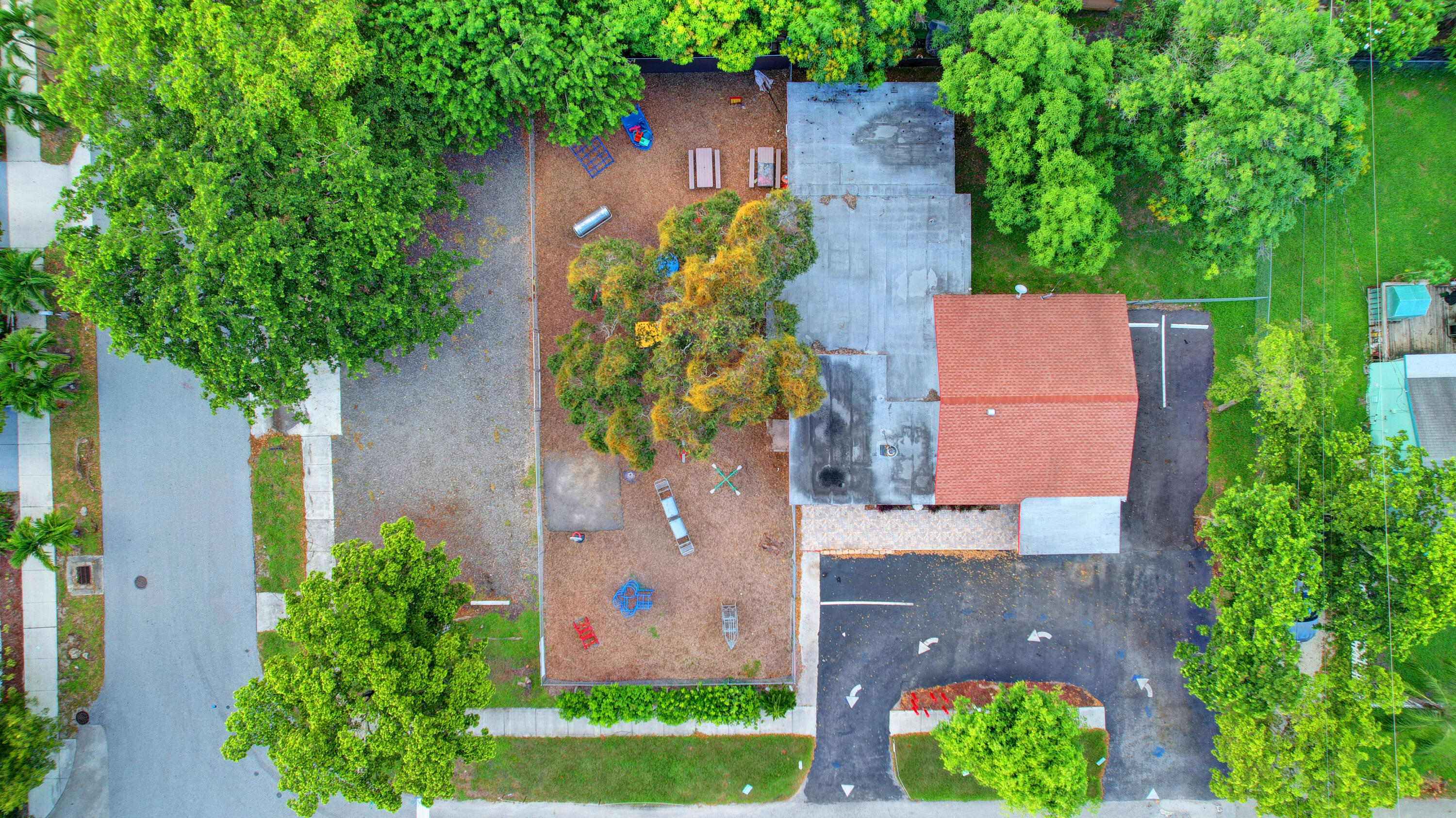 an aerial view of a house with a yard and a large tree