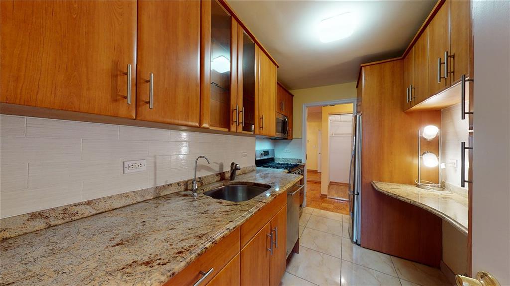 a kitchen with granite countertop a sink stove and cabinets