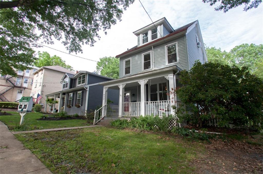 a front view of house with yard and green space