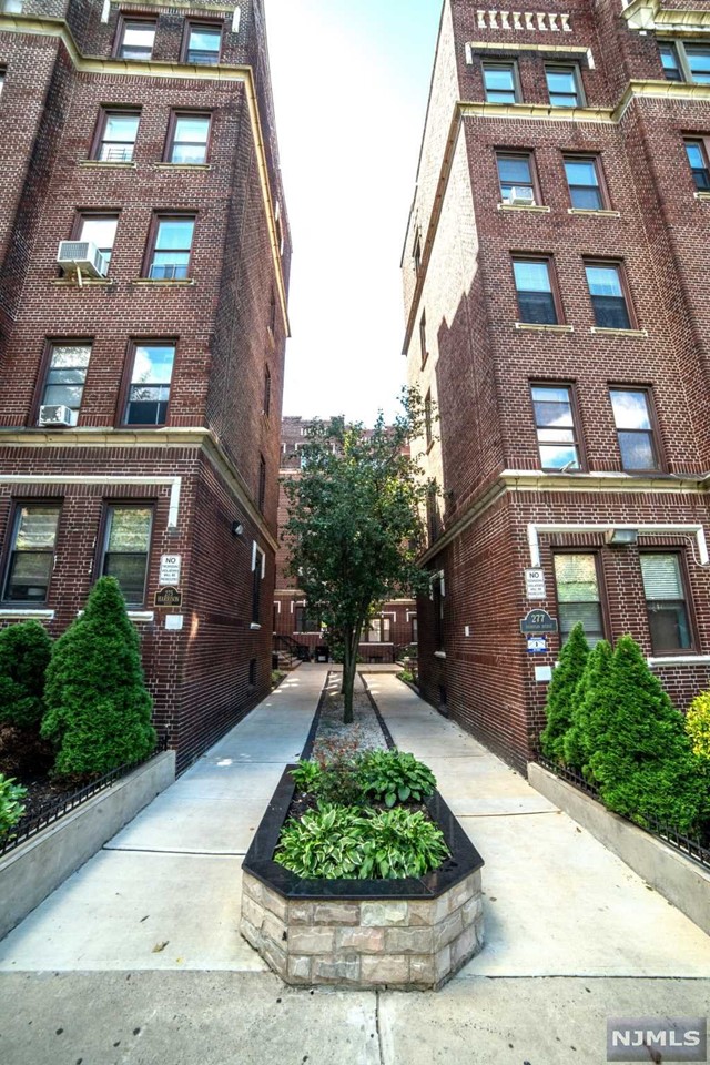 a front view of a multi story residential apartment building with a yard