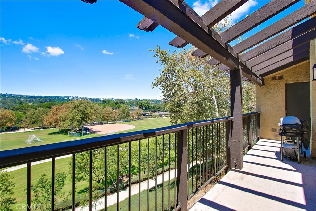 a view of a balcony with chairs and wooden fence