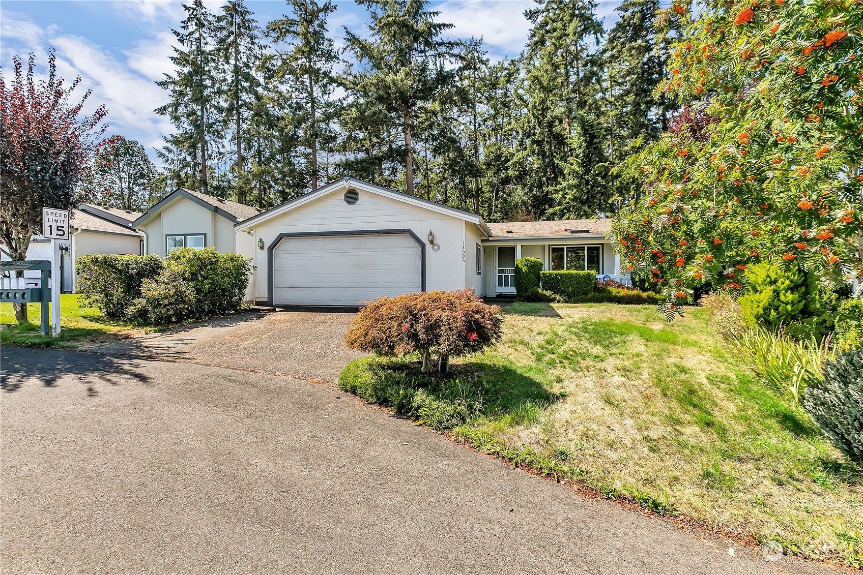 a front view of a house with a garden and trees