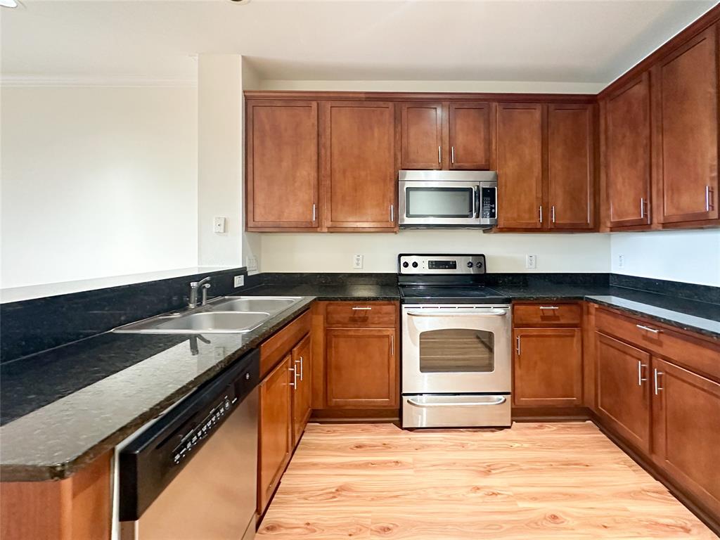 a kitchen with granite countertop wooden cabinets and a stove top oven