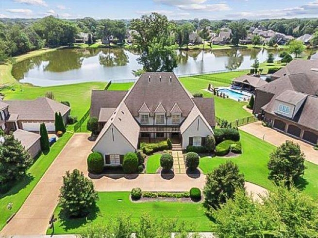 an aerial view of a house with garden space and a lake view