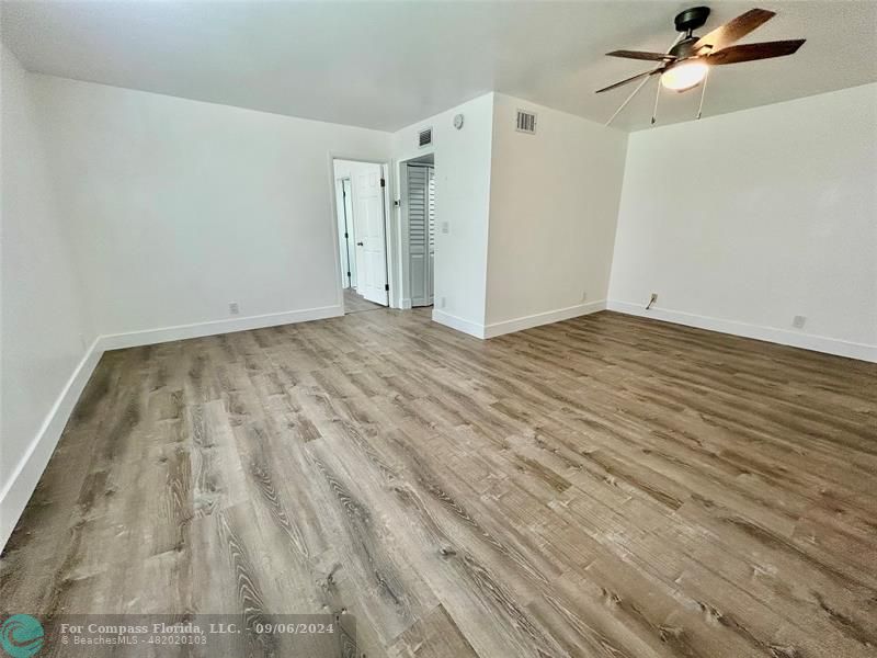 a view of empty room with wooden floor