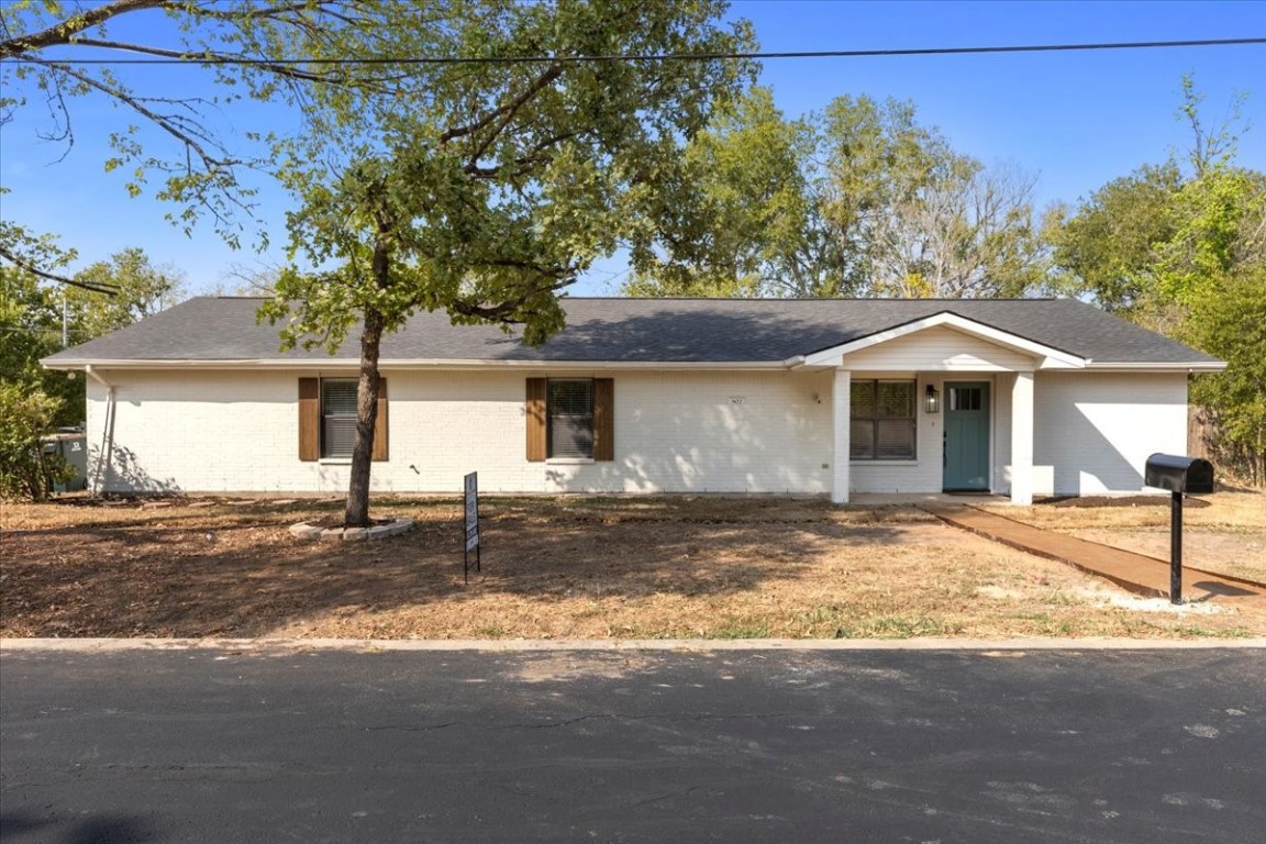 a front view of a house with a garden and yard