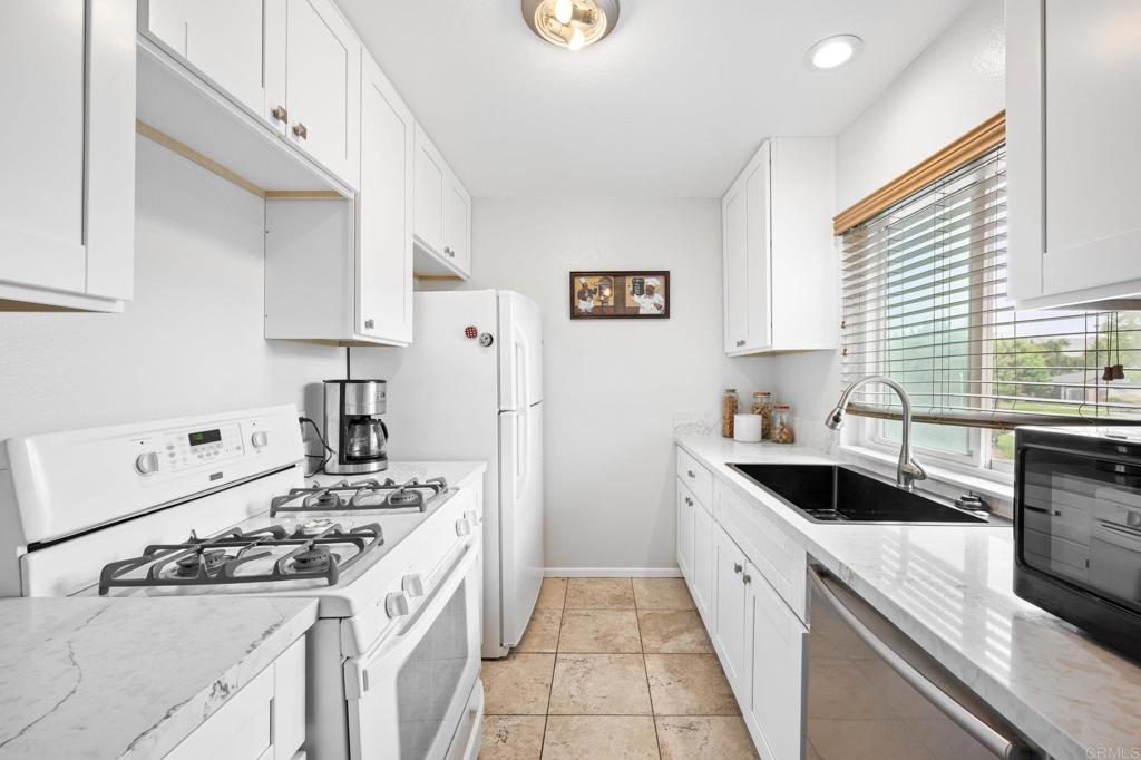 a kitchen with a sink stove top oven and cabinets