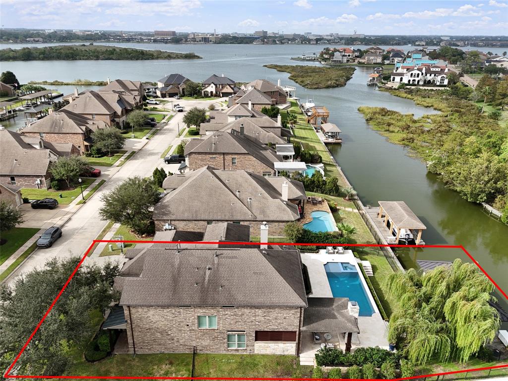 an aerial view of residential houses with outdoor space and lake view