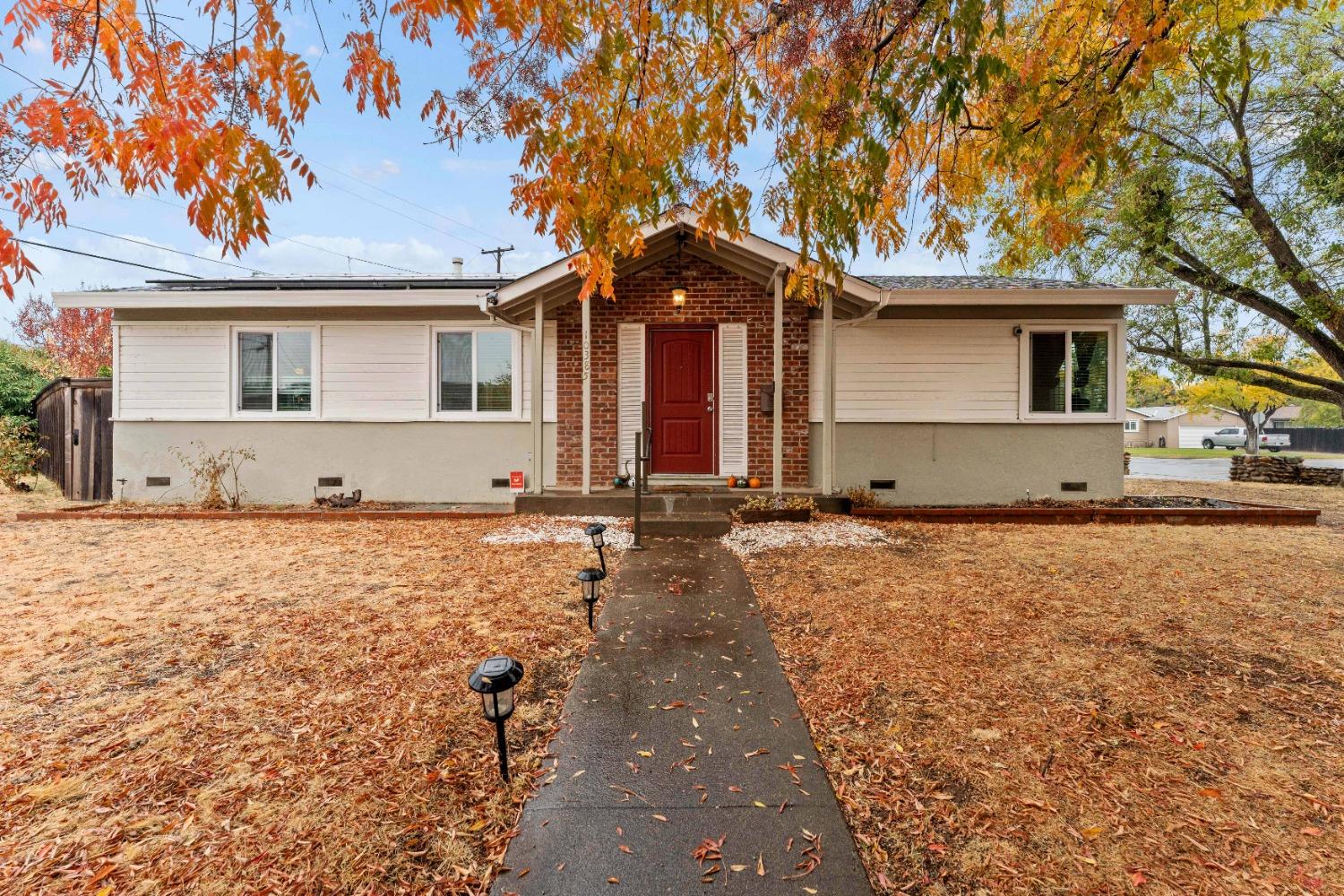 a front view of house with yard and trees in the background