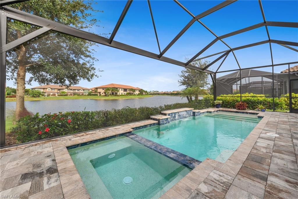 Pool with water feature and spa and a wide open view of the lake through the full panoramic screen enclosure!