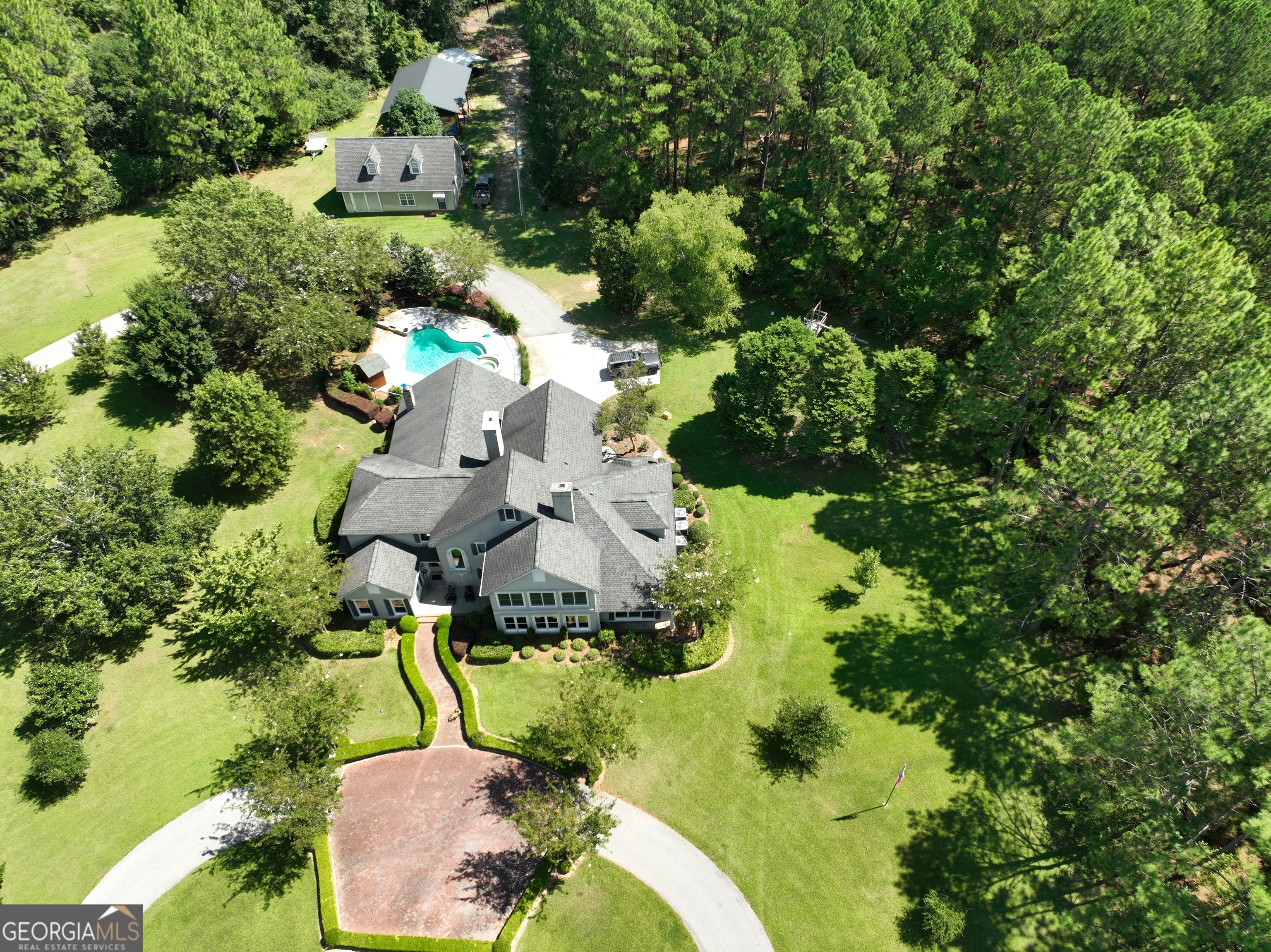 an aerial view of a house with a yard and trees