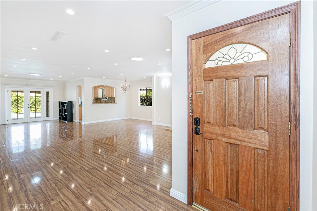 wooden floor in an entryway with a hallway