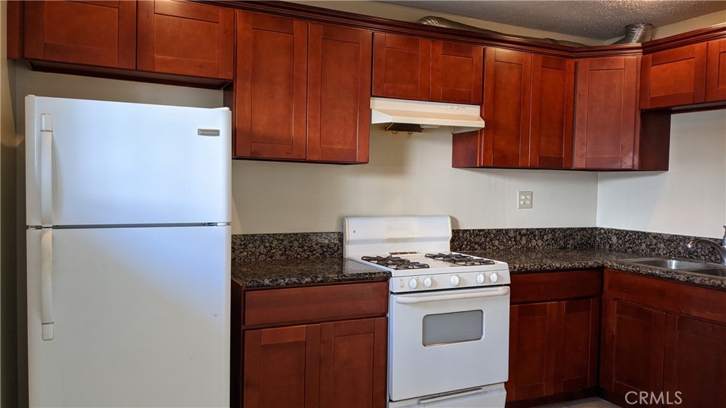 a kitchen with stainless steel appliances granite countertop a refrigerator stove a sink and dishwasher