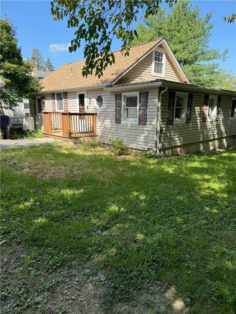 View of front facade with a deck and a front yard