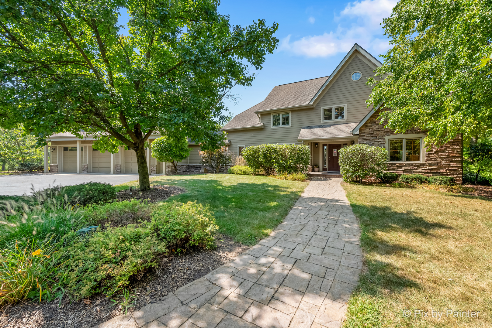 a front view of a house with a yard and trees