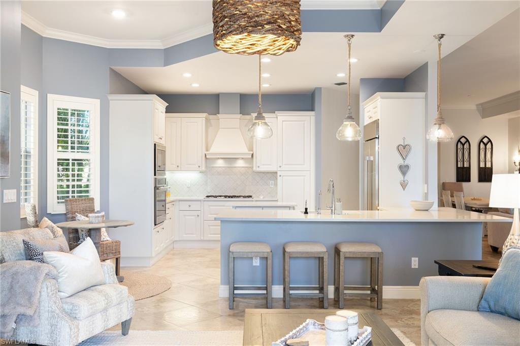 a large white kitchen with a large window cabinets and stainless steel appliances