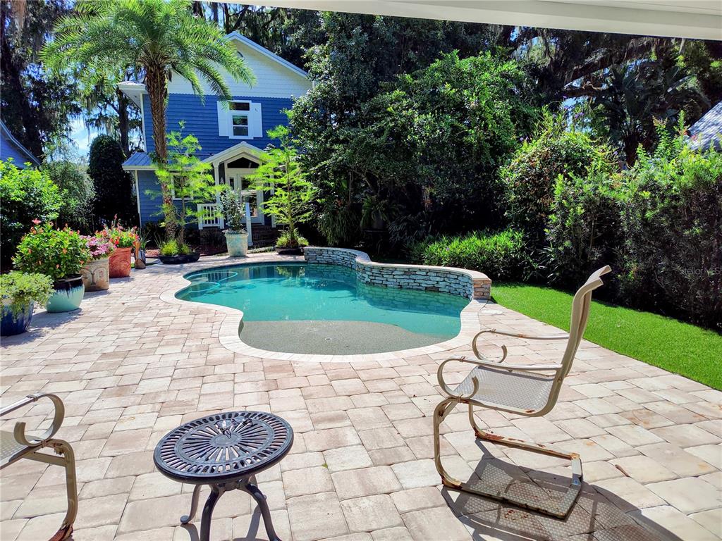 a view of a chairs and table in backyard of the house