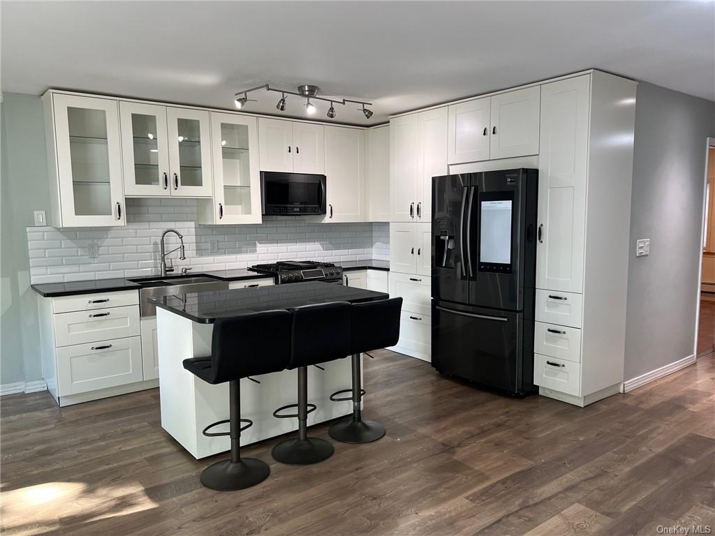 a kitchen with granite countertop a refrigerator stove and sink