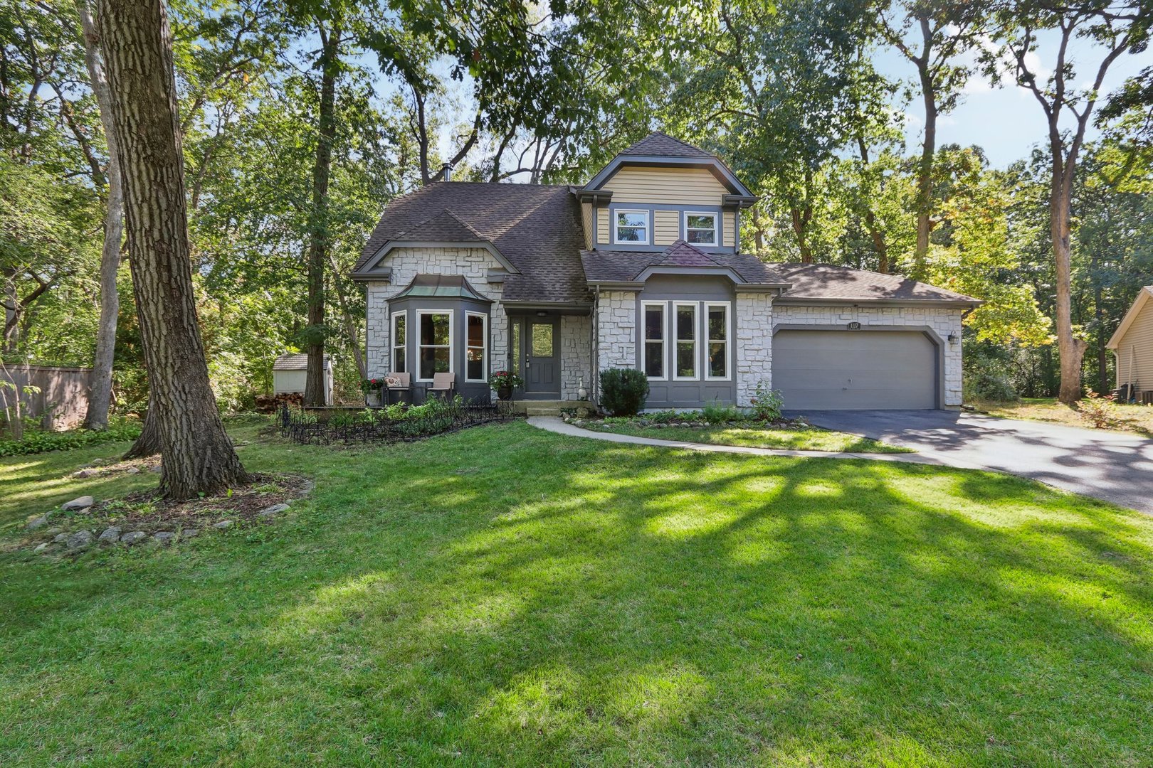 a front view of a house with a garden and yard