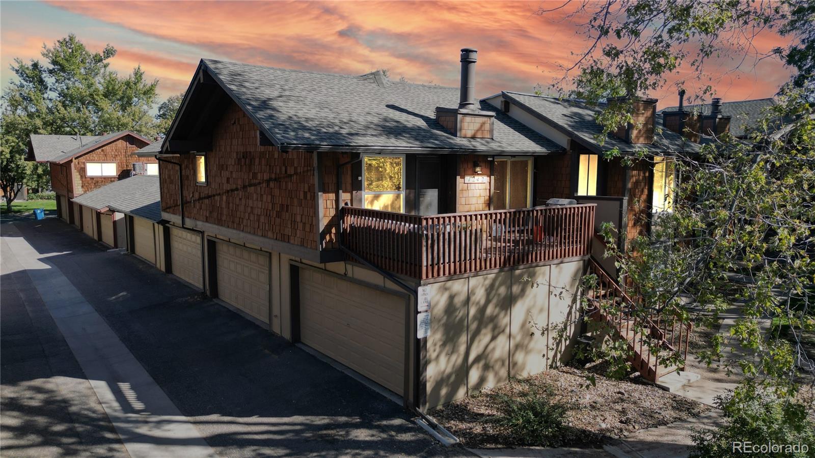 a front view of a house with large trees