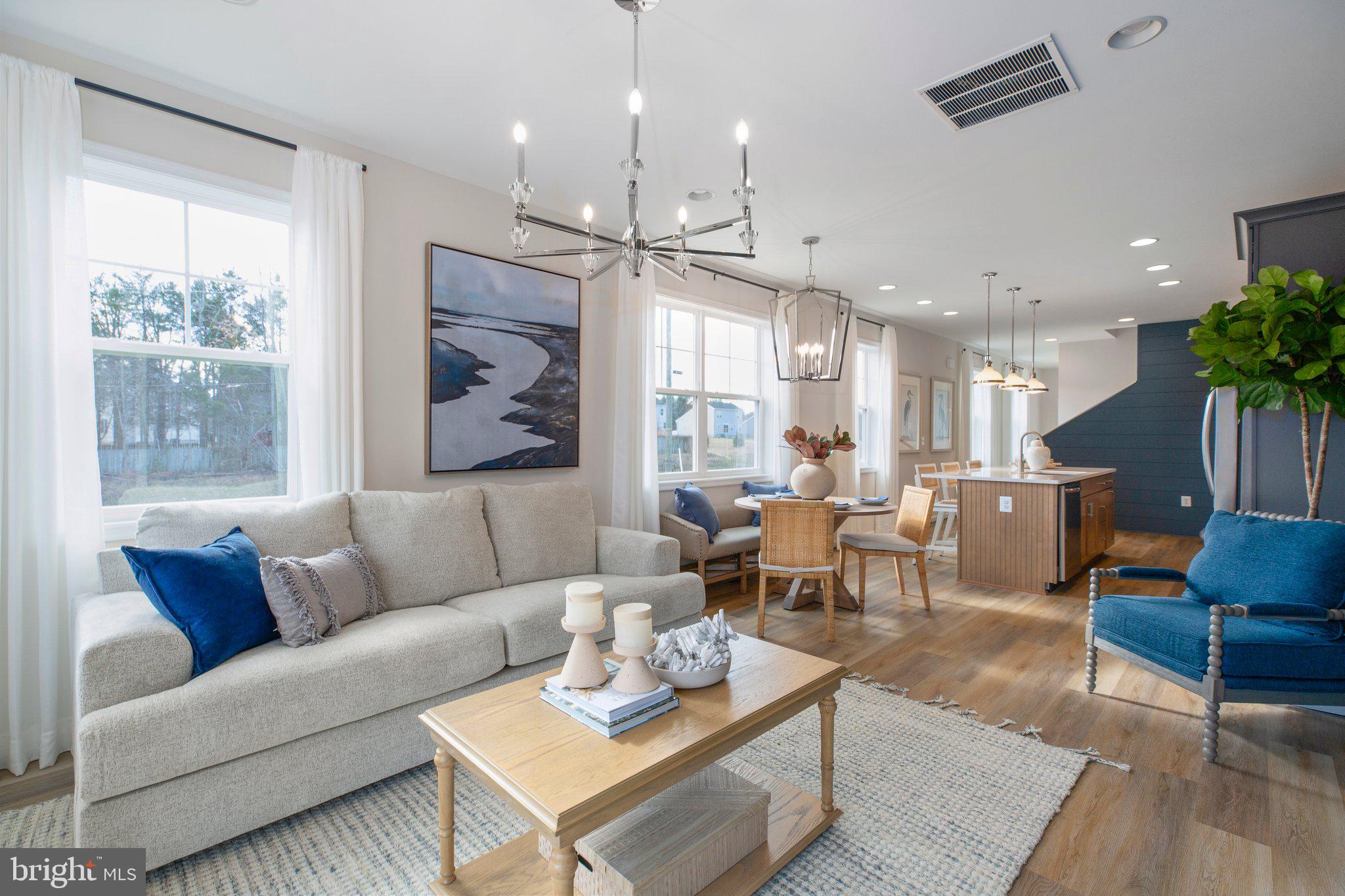 a living room with furniture kitchen view and a large window