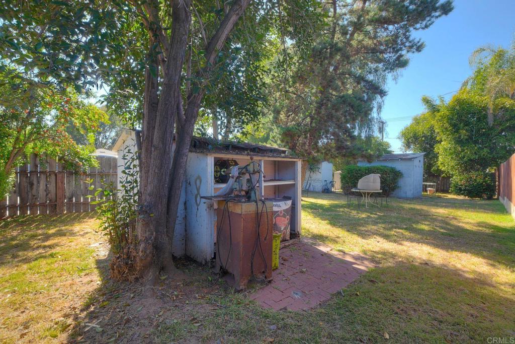 a view of a yard with large tree and wooden fence