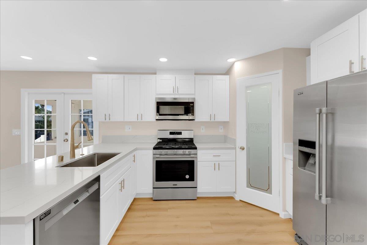 a kitchen with stainless steel appliances granite countertop a stove a refrigerator and a sink