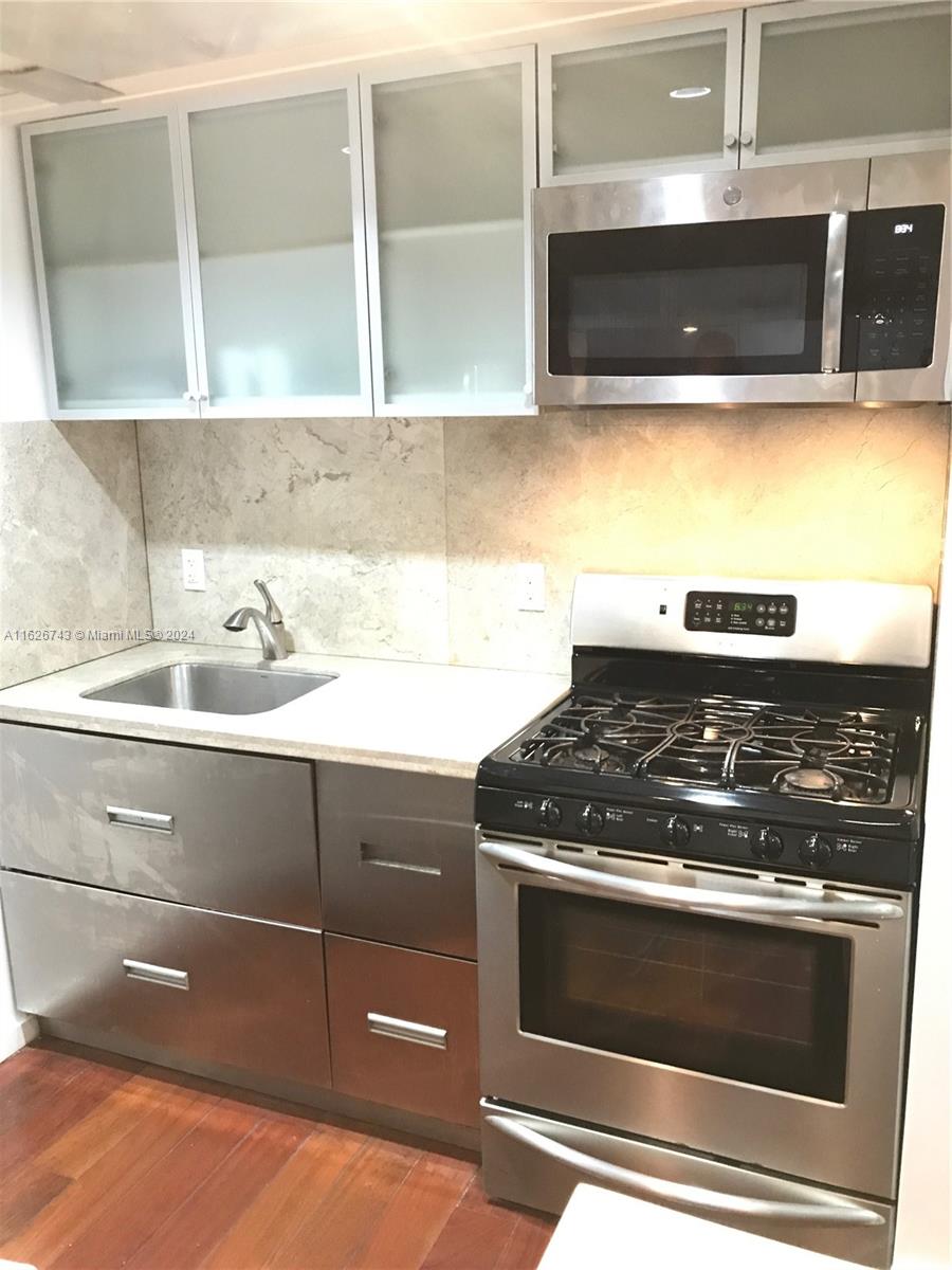 a stove top oven sitting inside of a kitchen