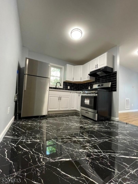 a kitchen with kitchen island granite countertop a stove and a refrigerator