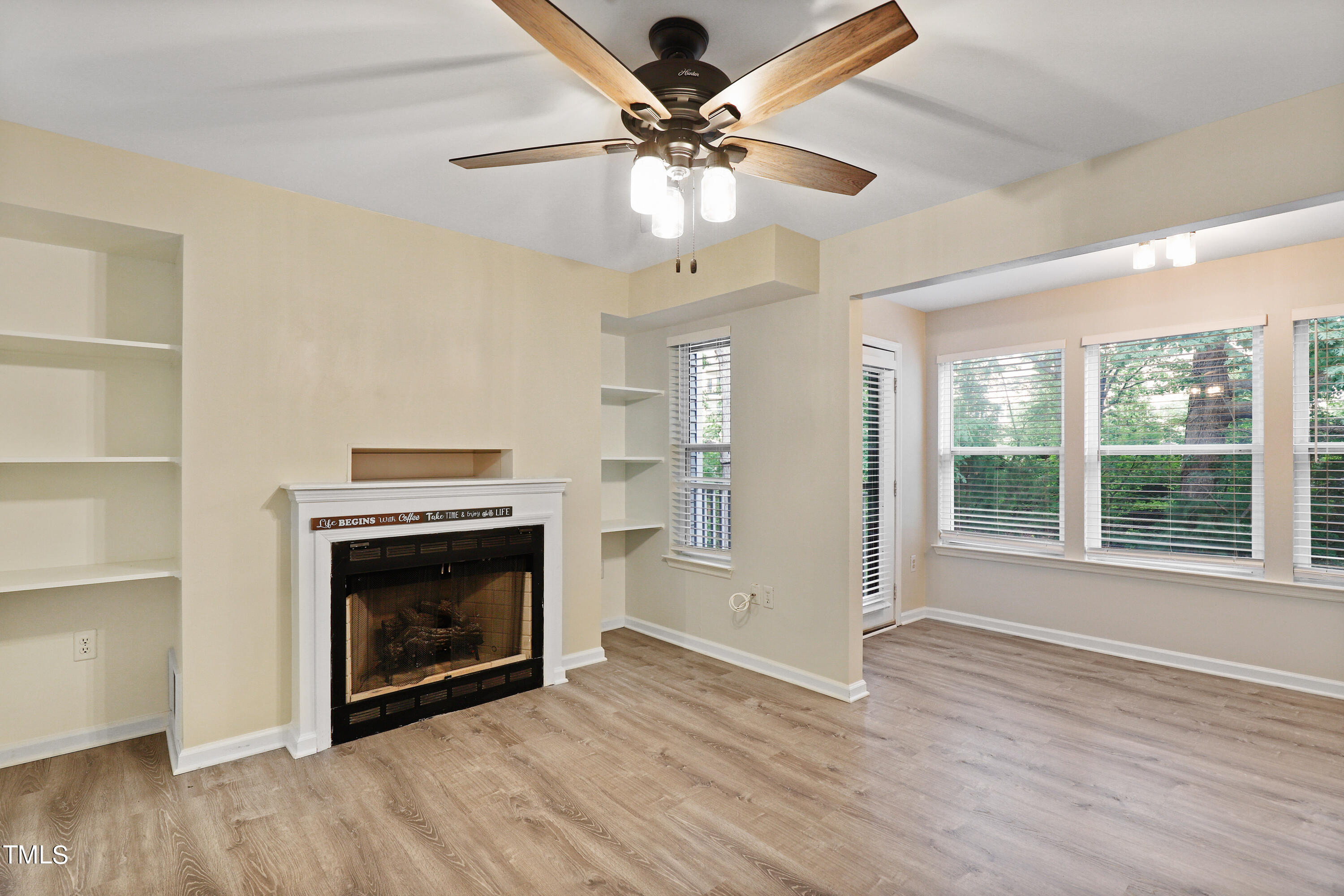 a view of an empty room with a fireplace and a window