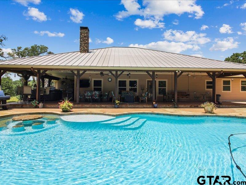 a view of a house with swimming pool and a yard