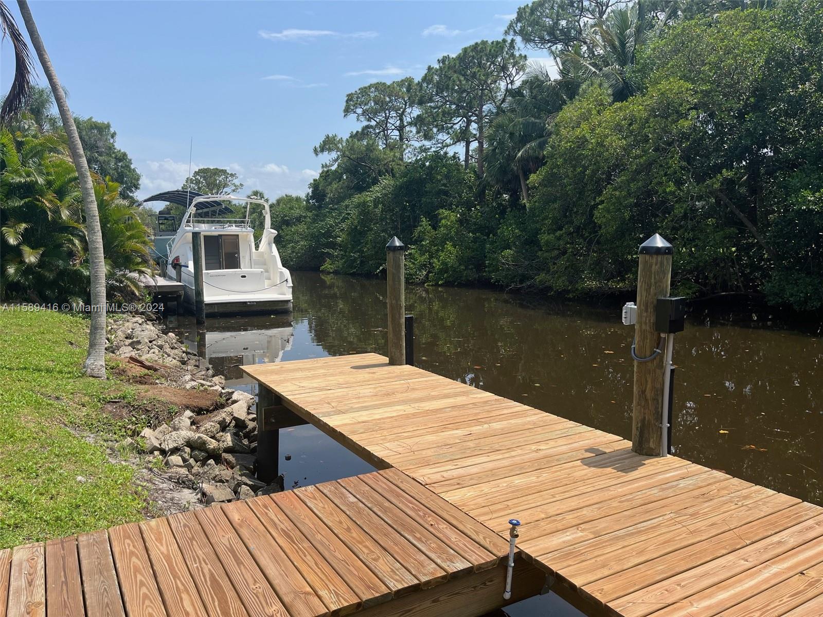 a view of a wooden deck and lake with trees in the background