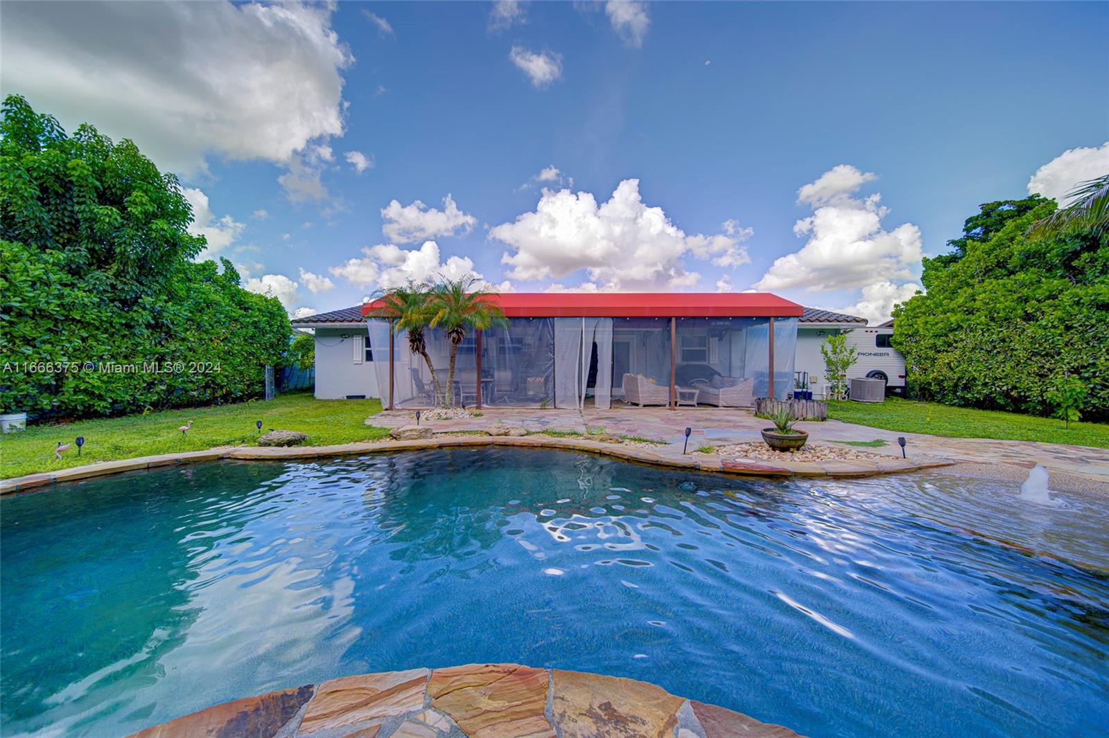 a view of a swimming pool with lounge chairs in patio